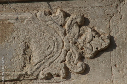 Texture of old stone from the sun lit facade of a medieval church in Crete