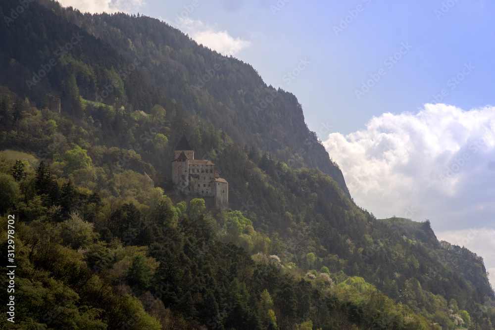 fortress on a steep mountainside. forest mountains