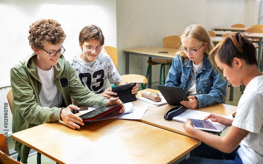 Teenagers in classroom using digital tablets Teenagers in classroom using digital tablets