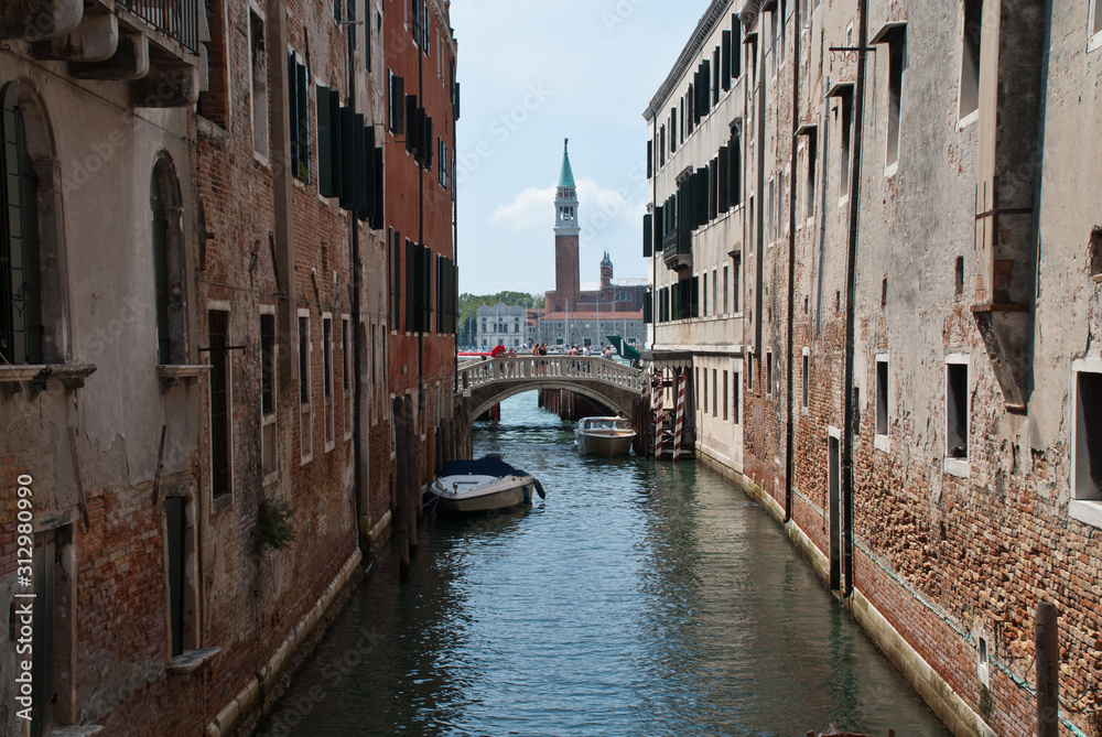 Venice, Italy: traditional buildings, canal Rio de la Pleta, district Castello, tower of church San Giorgio Maggiore in the background