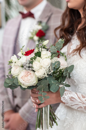 Groom and bride holding hands on the bouquet of flowers. bouquet bride female hand