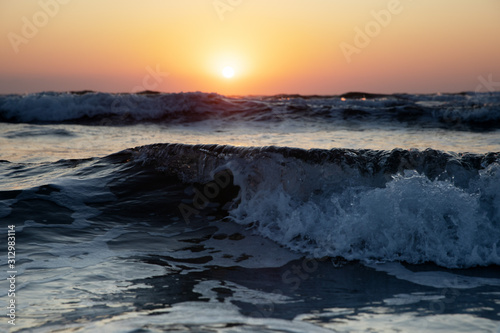 Waves of the Mediterranean Sea with sea foam and spray. Beautiful sea on sunset background. Sundown. Seascape. © Tetiana