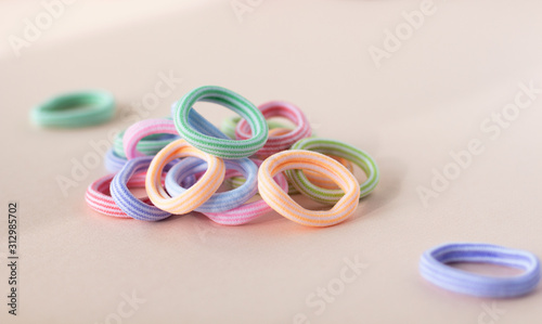 Many different colors of scrunchy on the soft beige background
