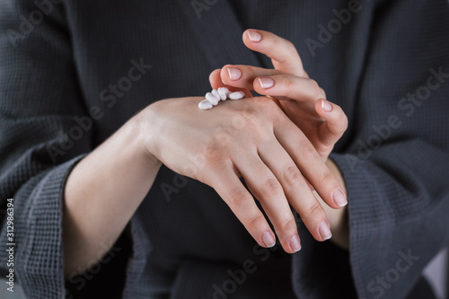 Close up of female hands applying hand cream.