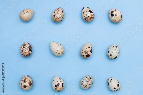 Pattern of quail eggs on a blue background. Minimal nutrition concept. easter background
