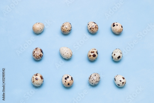 Pattern of quail eggs on a blue background. proper nutrition concept. easter background, minimalism,top view