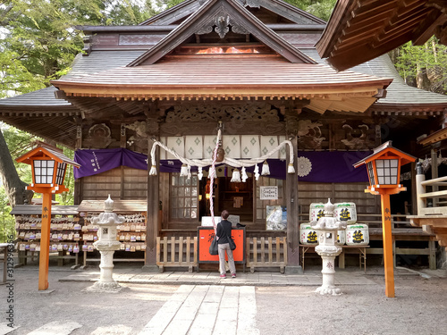 worshiper rings a bell at arakura sengen shrine in japan photo
