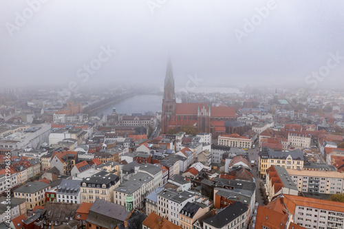 Aerial drone shot view of Schwerin Cathedral by the lake amist heavy morning fog haze smog