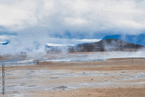 Mudpots in the geothermal area, al lot of steam, Hverir, Iceland. The area is multicolored and cracked.