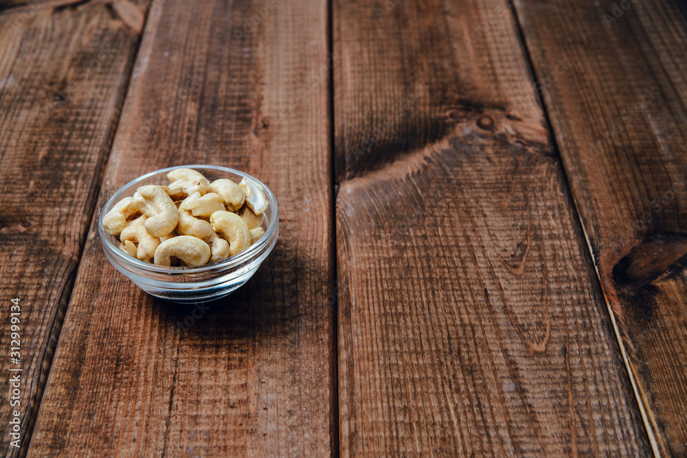 Cashews on a wooden background. The concept of eating nuts, giving them to a meal. Cashews on a wooden background. The concept of eating nuts, giving them to a meal.