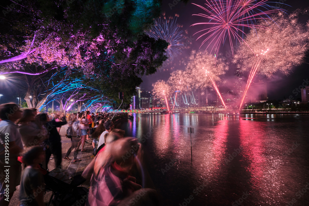 Brisbane Christmas fireworks with colourful trees and people lining the banks of the Brisbane River at Southbank
