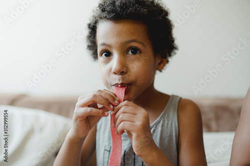 Portrait of boy eating candy at home photo