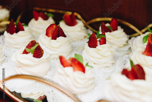 Close up of tasty cream desserts with strawberries