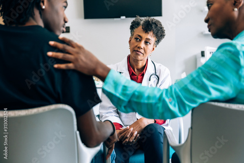 Doctor consulting young patient and grandmother