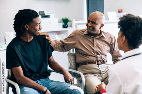 Doctor consulting young patient and grandfather
