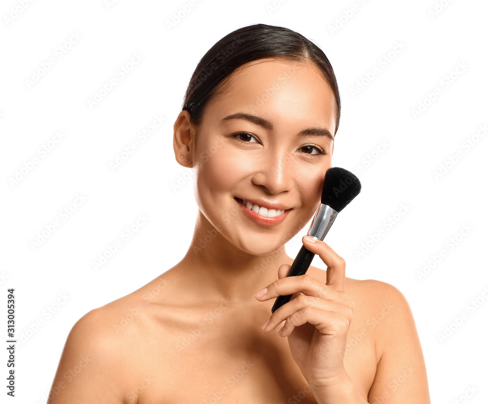 Portrait of young Asian woman with makeup brush on white background Portrait of young Asian woman with makeup brush on white background