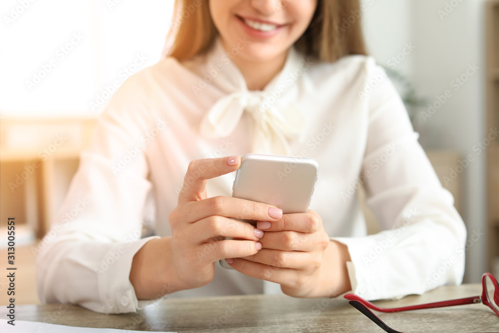 Young businesswoman with mobile phone indoors, closeup Young businesswoman with mobile phone indoors, closeup
