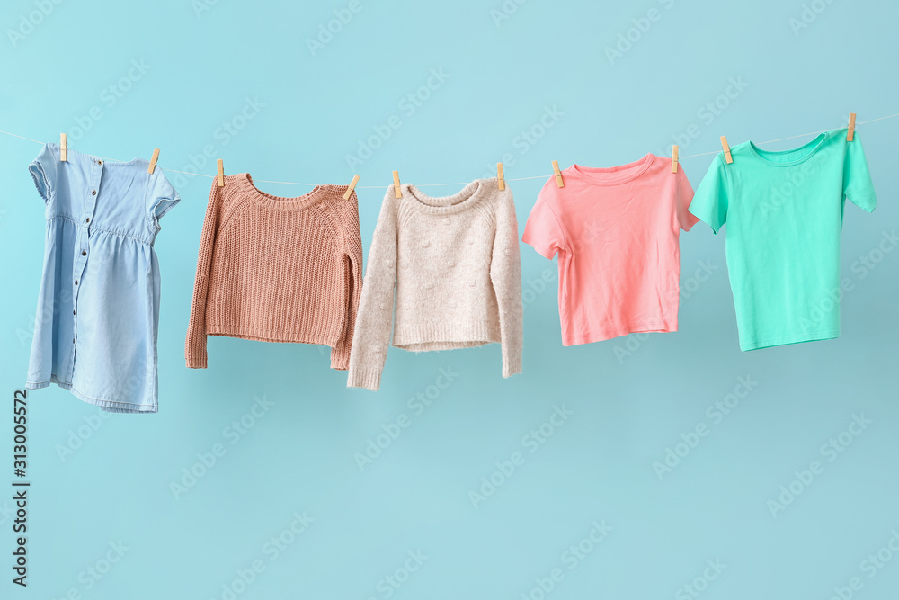 Clean laundry hanging on line against color background Clean laundry hanging on line against color background