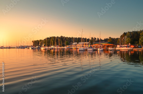 Boats docking in the marina at the Niegocin Lake during sunrise - Wilkasy, Masuria, Poland.