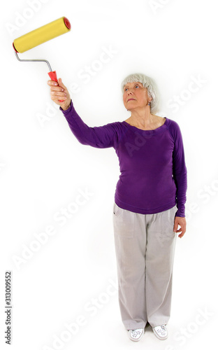 elderly charming woman makes repairs on a white background. Active pension. Hobbies of people. Do-it-yourself construction with tools.