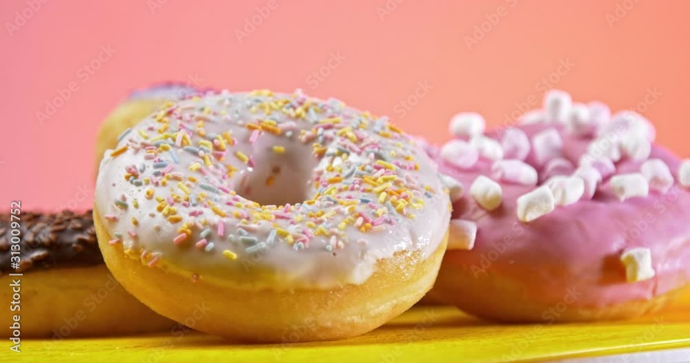 Donuts rotating on table with pink background Donuts rotating on table with pink background