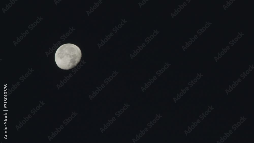 Steady, medium wide shot of a full moon in the dark sky. Steady, medium wide shot of a full moon in the dark sky.