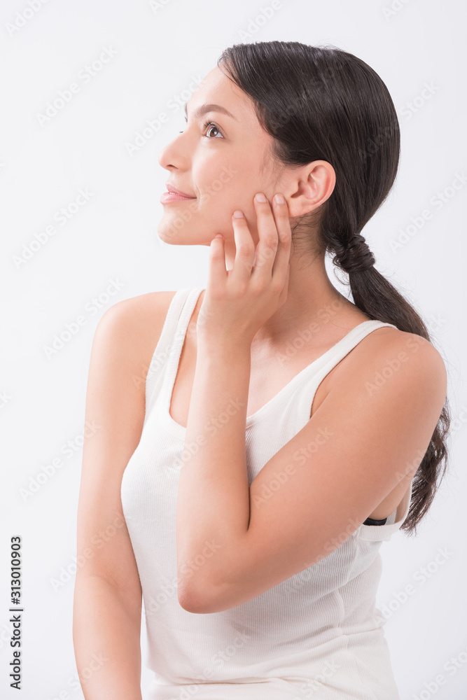 beautiful young woman with clean fresh skin touch own face . facial treatment . cosmetology , beauty and spa . beautiful young woman with clean fresh skin touch own face . facial treatment . cosmetology , beauty and spa .