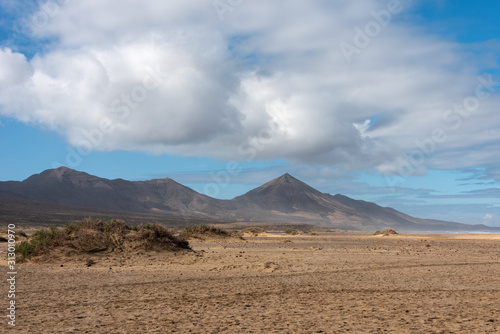 Cofete beach, Fuerteventura, Canary Islands. Cloudy sky and high mountains in the background. Selective focus. 