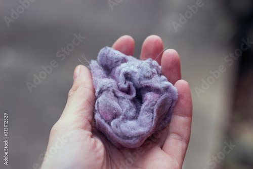 Fluff / lint on laundry after removing from clothing dryer isolated on white background.Woman & man's hand