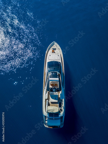 Aerial vertical shot of a yacht sailing on the sea © SPIX PRODUCTION