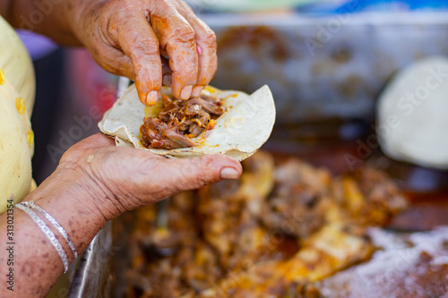unrecognizable woman prepares traditional mexican cochinita pibil tacos