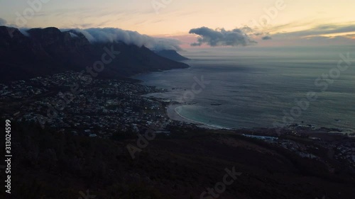 Camps Bay, surrounding mountains and open ocean seen from Lion's Head at dusk