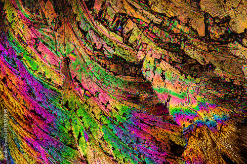 Extreme macro photograph of Potassium Citrate crystals forming abstract modern art patterns, when illuminated with polarized light, under a microscope objective with 10x magnification