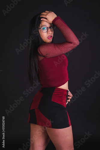Young girl model posing in black background studio with red party t-shirt