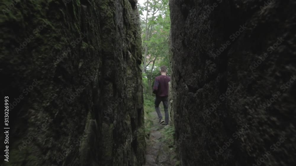 Man is moving out of a dark crack in a mountain. Man is moving out of a dark crack in a mountain.