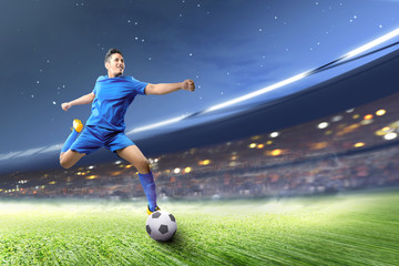 Asian football player man kicking the ball on the football field