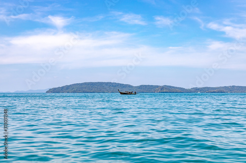 A longtail boat sailing in andaman sea off the coast of Thailand near Railay beach.