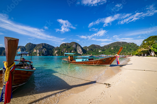 traditional wooden longtail boats parked at a beach in Phi Phi Island. Clear water and clean beach. © asiraj