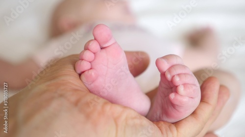Newborn Baby Feet In Father Hands. Close-Up. © di_media