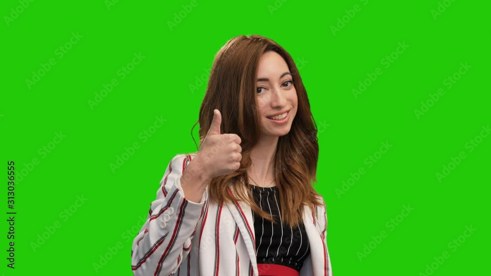 Cute smiling girl pose on green screen showing heart and thumb up gestures Cute smiling girl pose on green screen showing heart and thumb up gestures