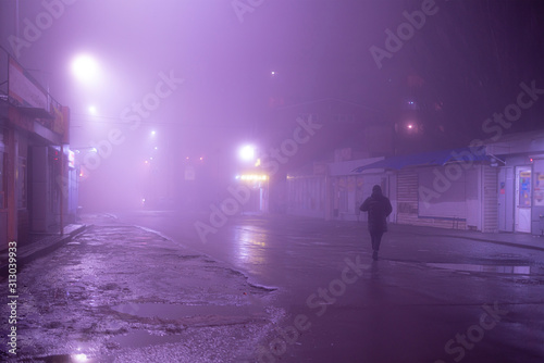 the cyberpunk style  person walk alone in the dark city during foggy weather