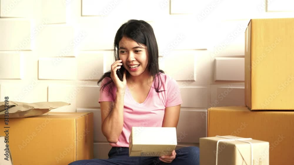 Asian Women business owner working at home with packing box on workplace Asian Women business owner working at home with packing box on workplace