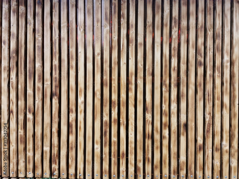 Wooden thin slats with traces of firing. Thin vertical slats.Wooden background. Abstract background. Wooden thin slats with traces of firing. Thin vertical slats.Wooden background. Abstract background.