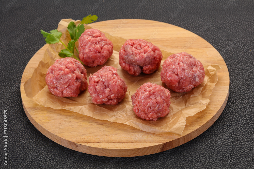 Raw meatball over wooden background Raw meatball over wooden background