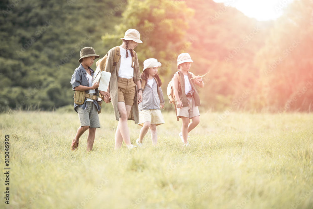 Fototapeta premium Happy asian woman girl and children goes to summer travel trip with mountain background. they checks map to find directions. Smile and enjoying their time together. Travel and adventure concept.
