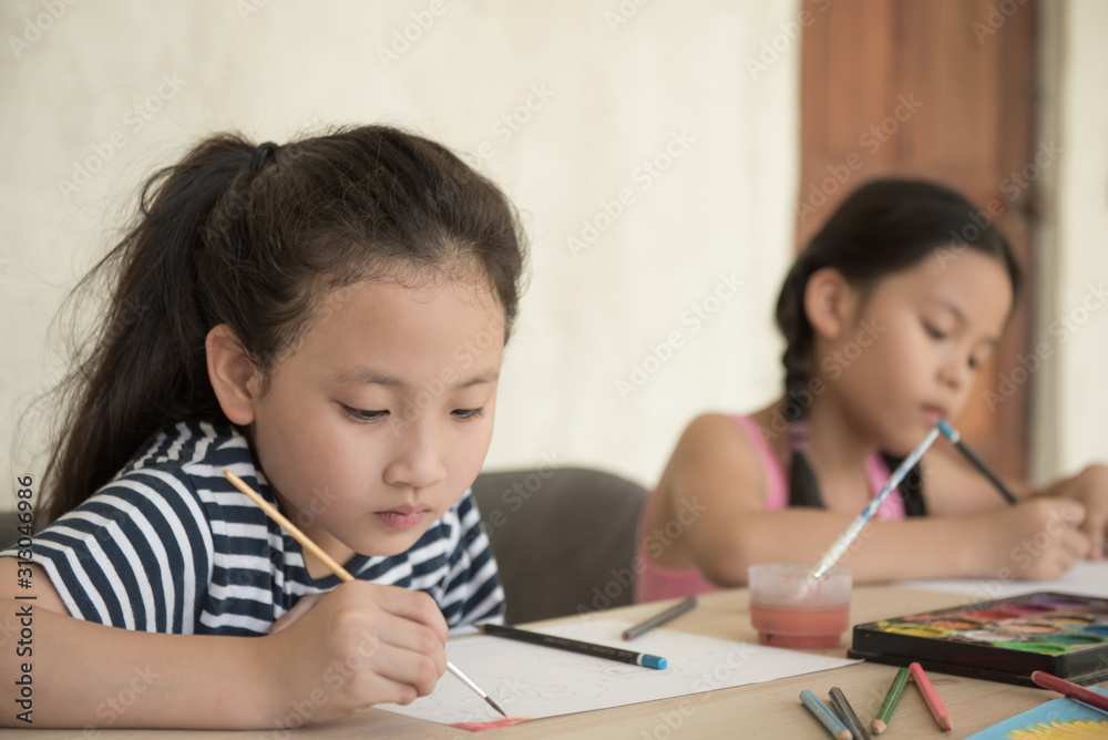 group little girl with brush painting on table in School, education, cut girl painting in at her home. Selective focus and small depth of field, Painting with watercolor, drawing, Creativity concept. group little girl with brush painting on table in School, education, cut girl painting in at her home. Selective focus and small depth of field, Painting with watercolor, drawing, Creativity concept.