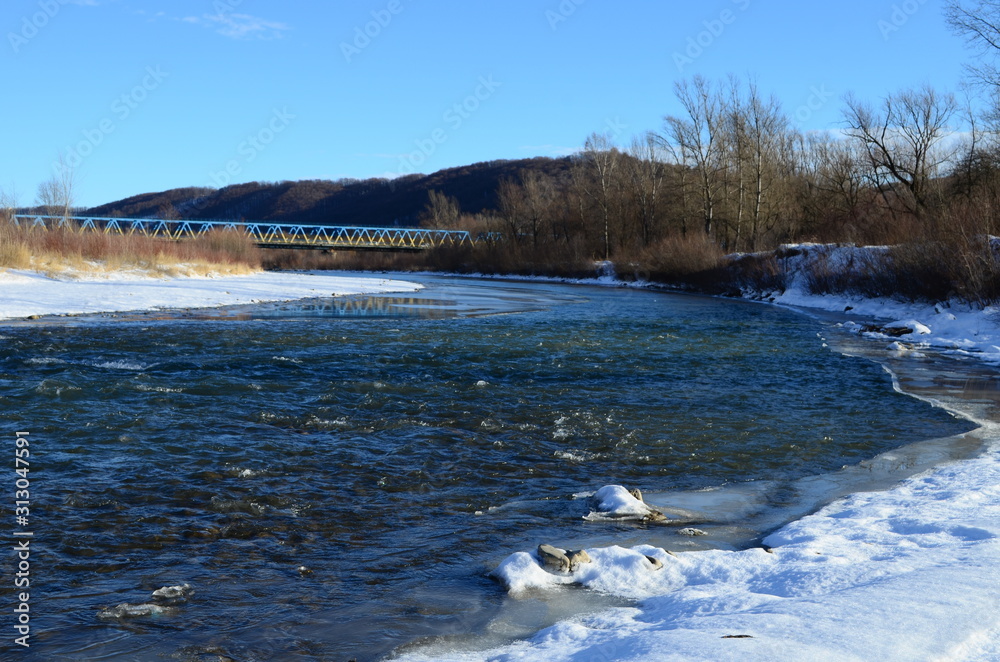winter landscape in the forest with snow and blue sky and river winter landscape in the forest with snow and blue sky and river