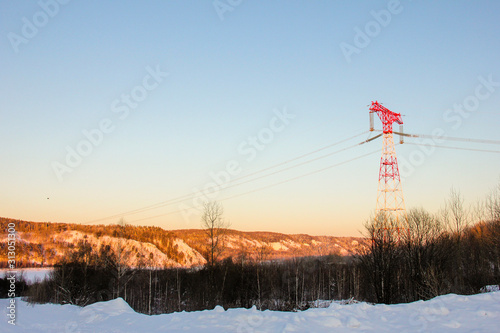 power lines stand on the background of the snowy Siberian landscape © Evgeniya