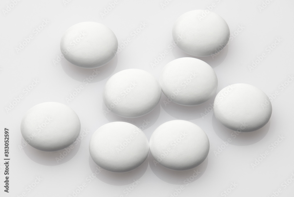 Group of white pills on white background - healthcare and medicament concept. Pharmaceutical industry. Pharmacy. Group of white pills on white background - healthcare and medicament concept. Pharmaceutical industry. Pharmacy.