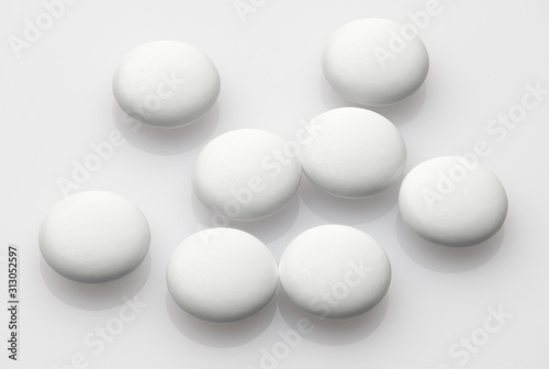 Group of white pills on white background - healthcare and medicament concept. Pharmaceutical industry. Pharmacy.